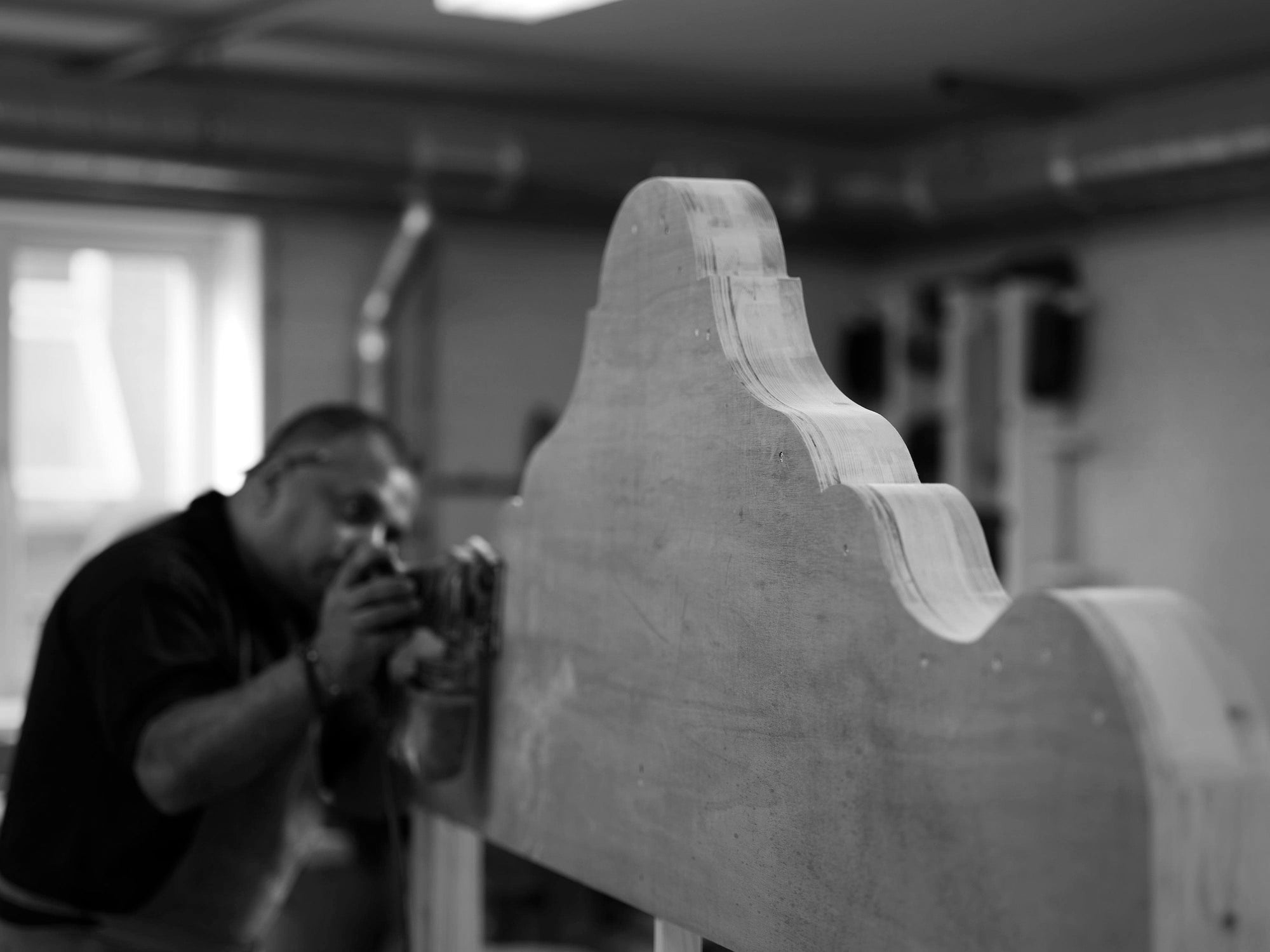 A Savoir craftsman working on a headboard