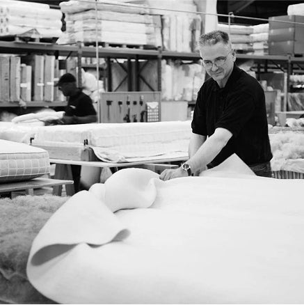 A Savoir craftsman laying down a natural material fabric sheet