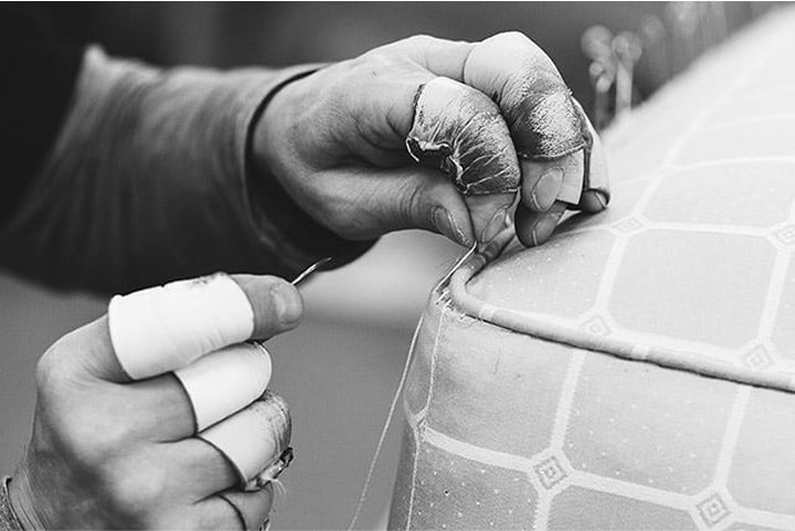 Close-up of craftsman stitching a side mattress