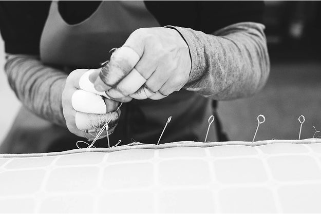 Savoir craftsman adding needles on a mattress