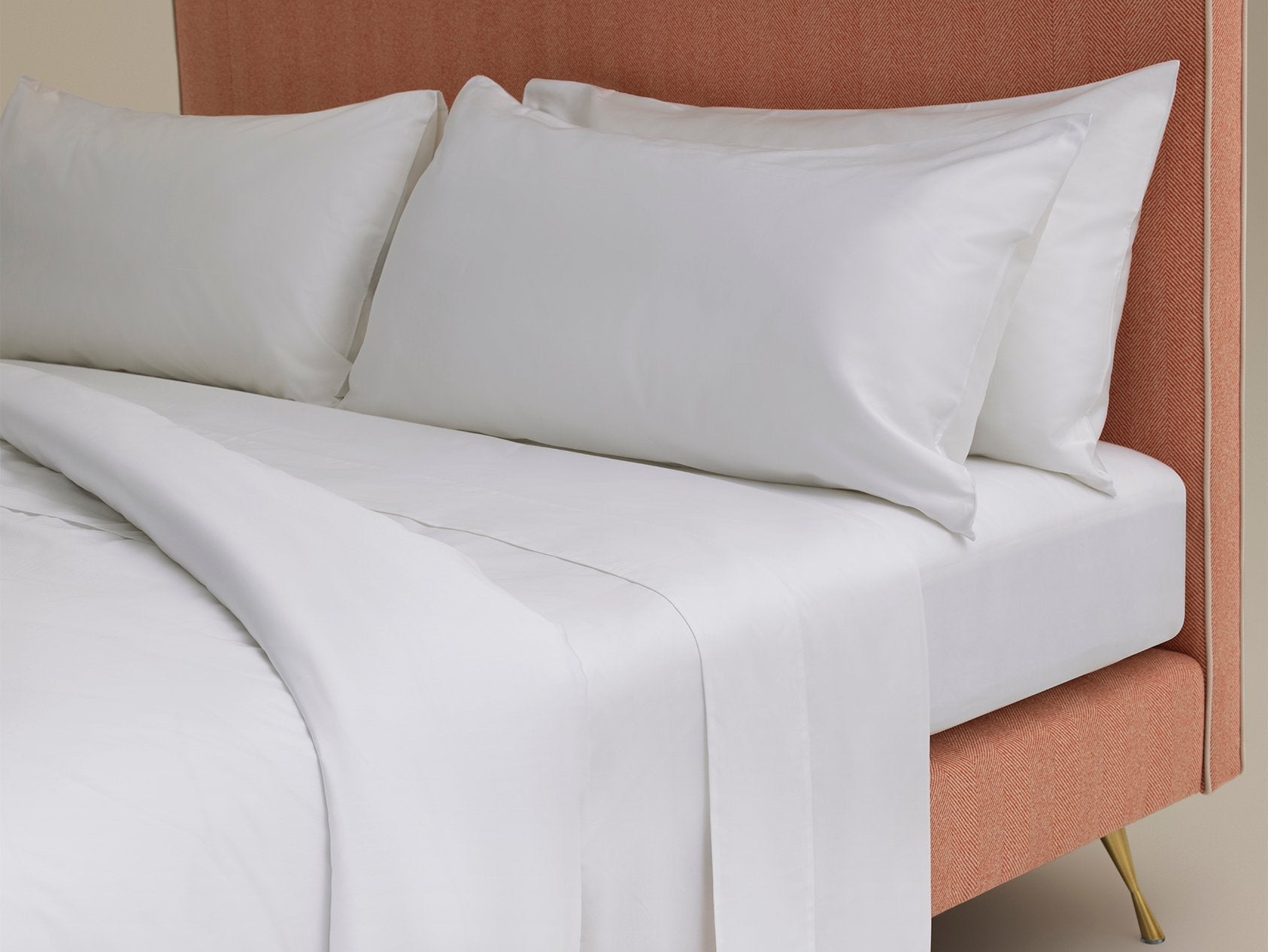 Cotton sateen bed linen photographed with a pink salmon fabric Harlech headboard