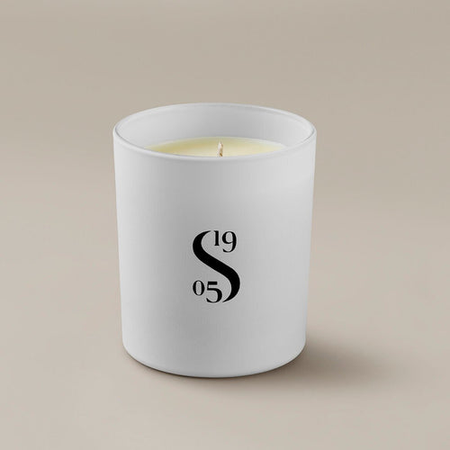 Savoir candle with the Savoir logo at the front