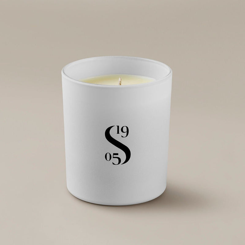 Savoir candle with the Savoir logo at the front