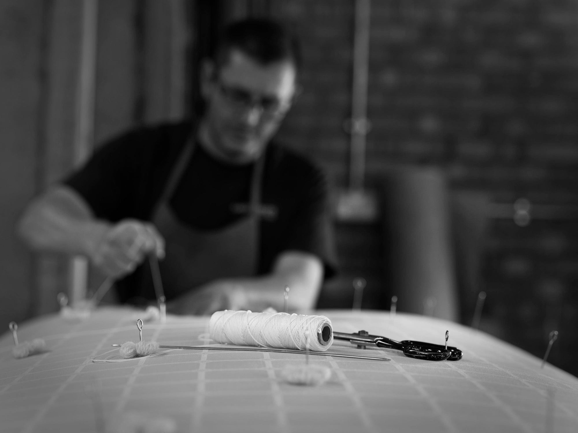 A craftsman adding pins into a mattress