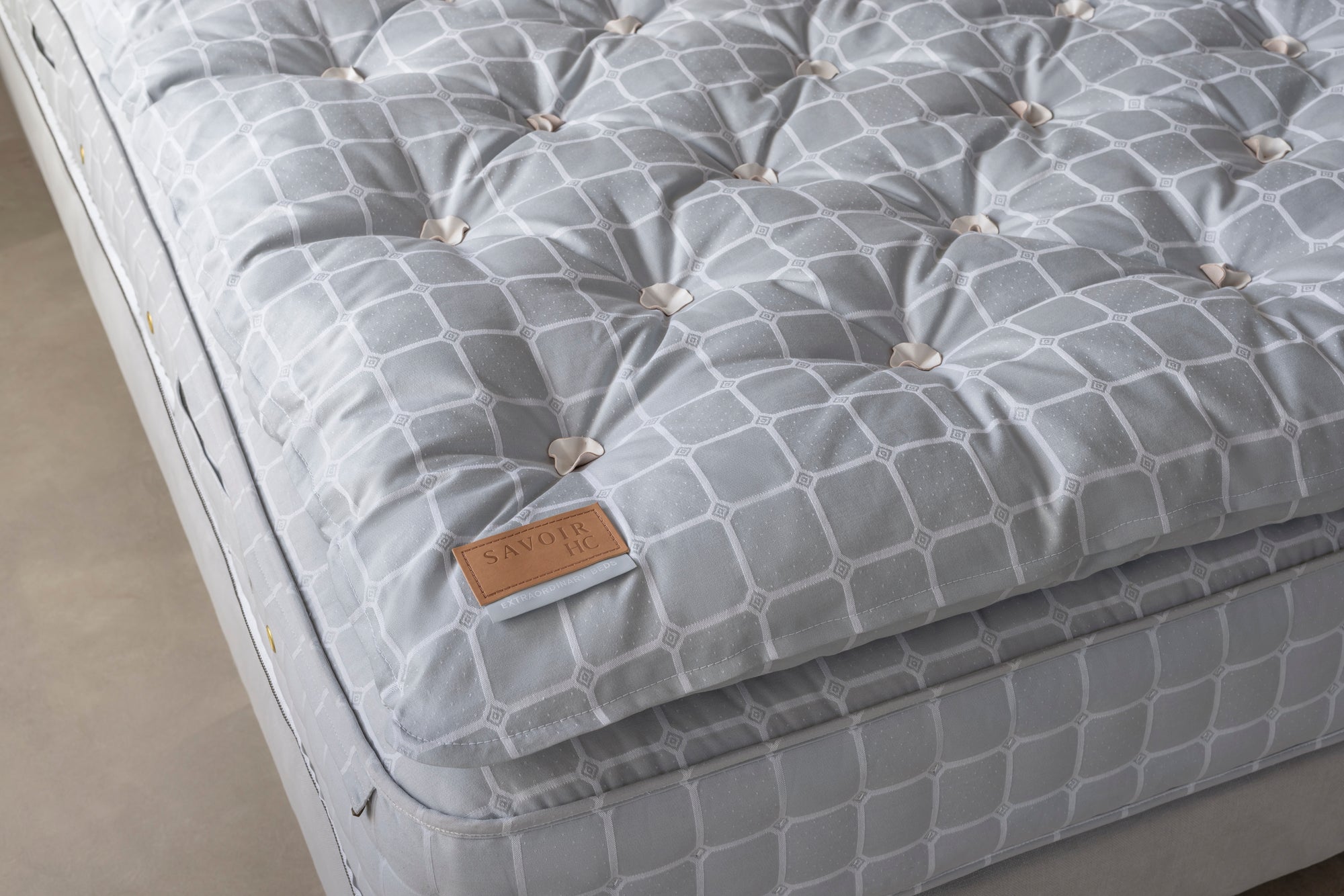 Corner of a Savoir HC topper on grey mattress