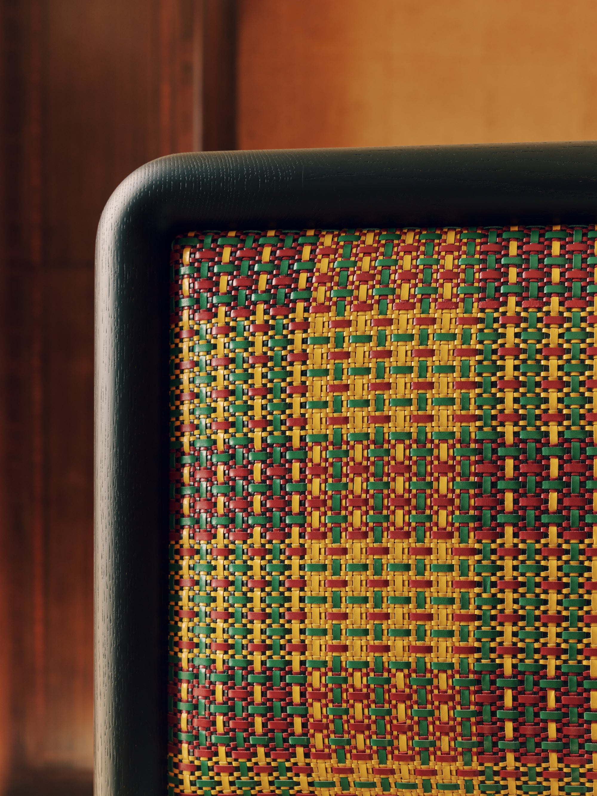 Close-up of a headboard with a colourful woven pattern on a wooden background