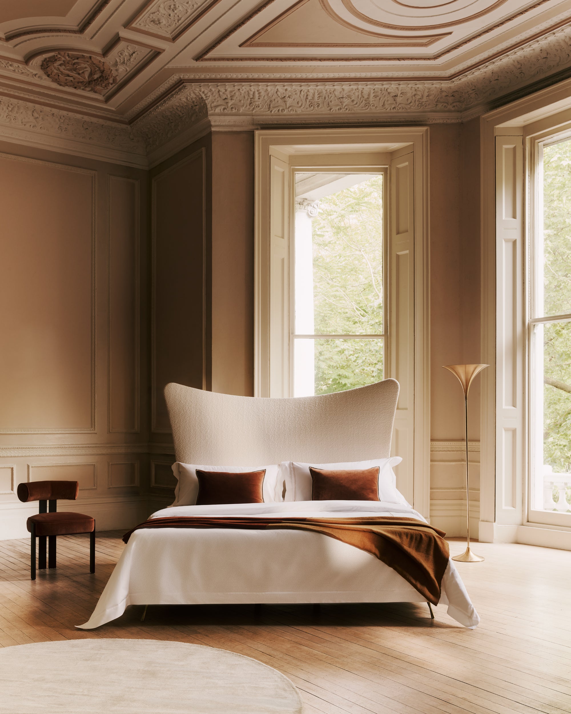 Luxurious bedroom with the Amelia bed, decorative pillows, and a chair.