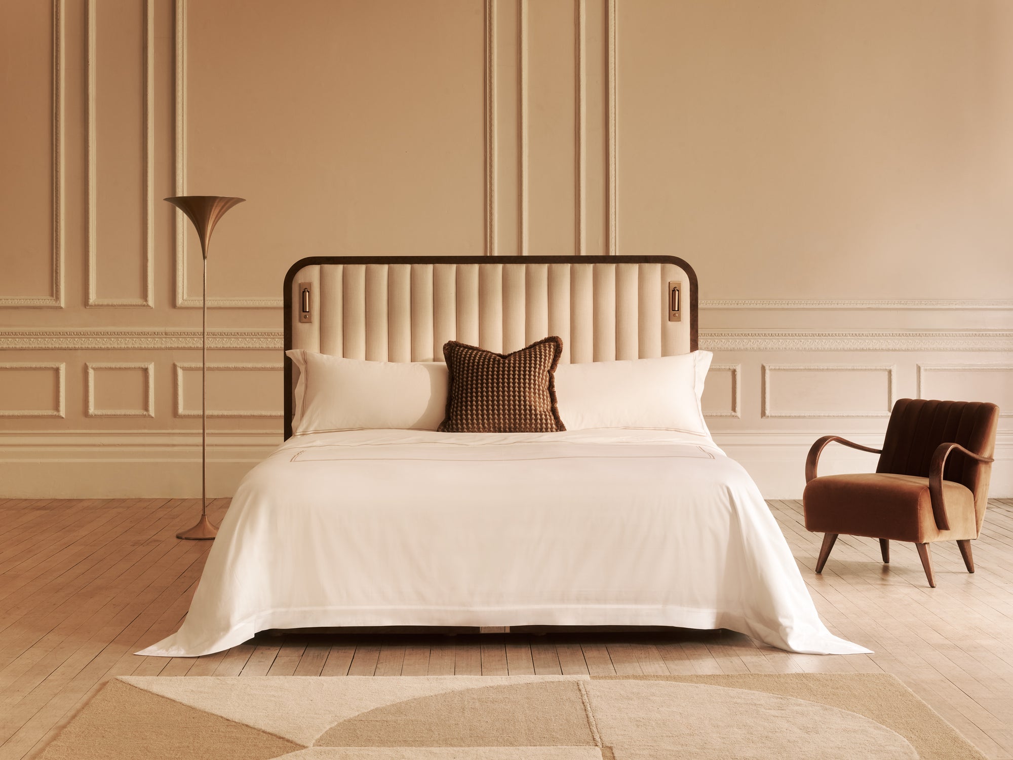 The Luna bed with white bedding and decorative pillows in a bedroom setting.