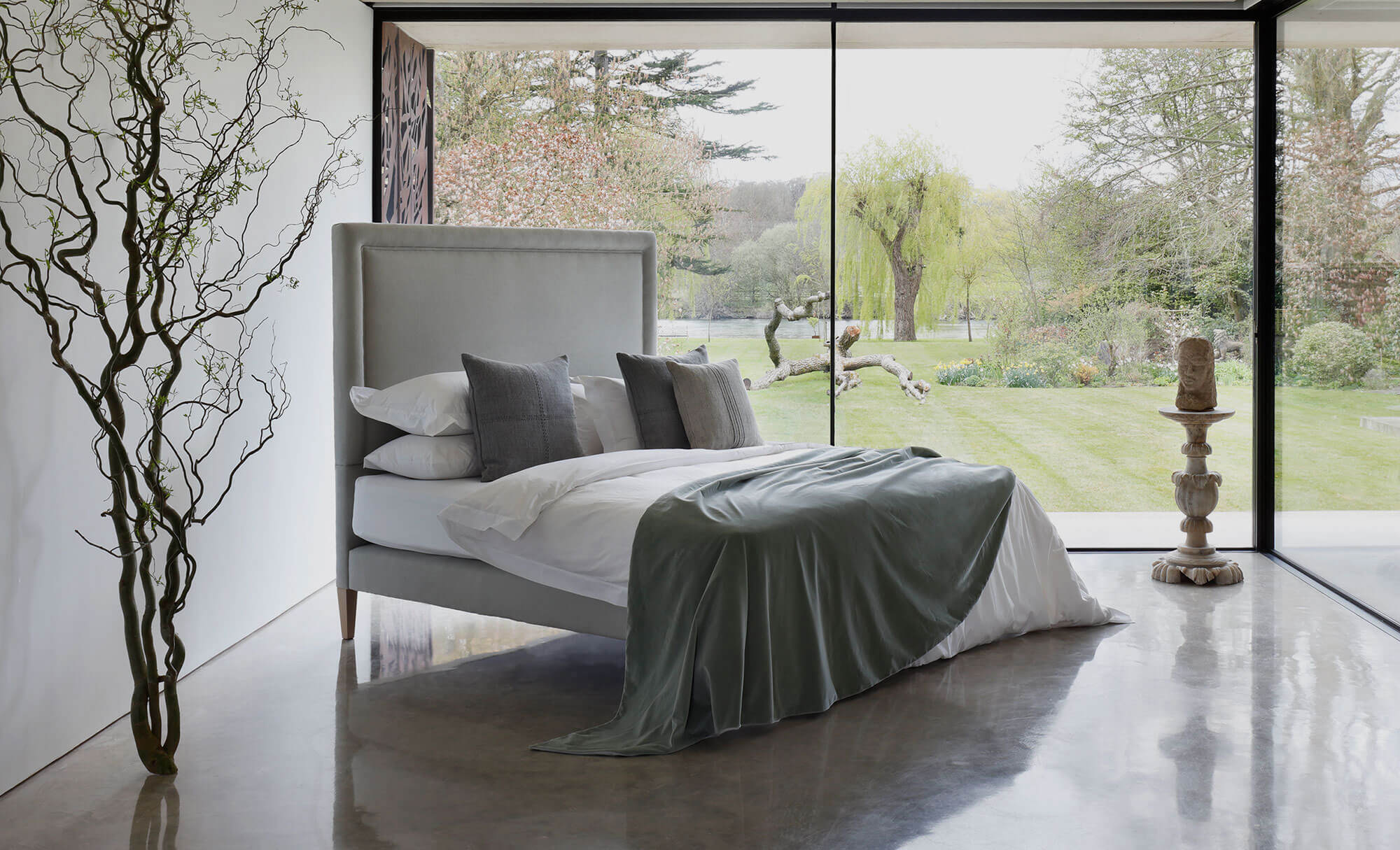 View on the No 4 Vegan luxury beds with white and grey bedding, photographed in a contemporary home with a polished concrete floor