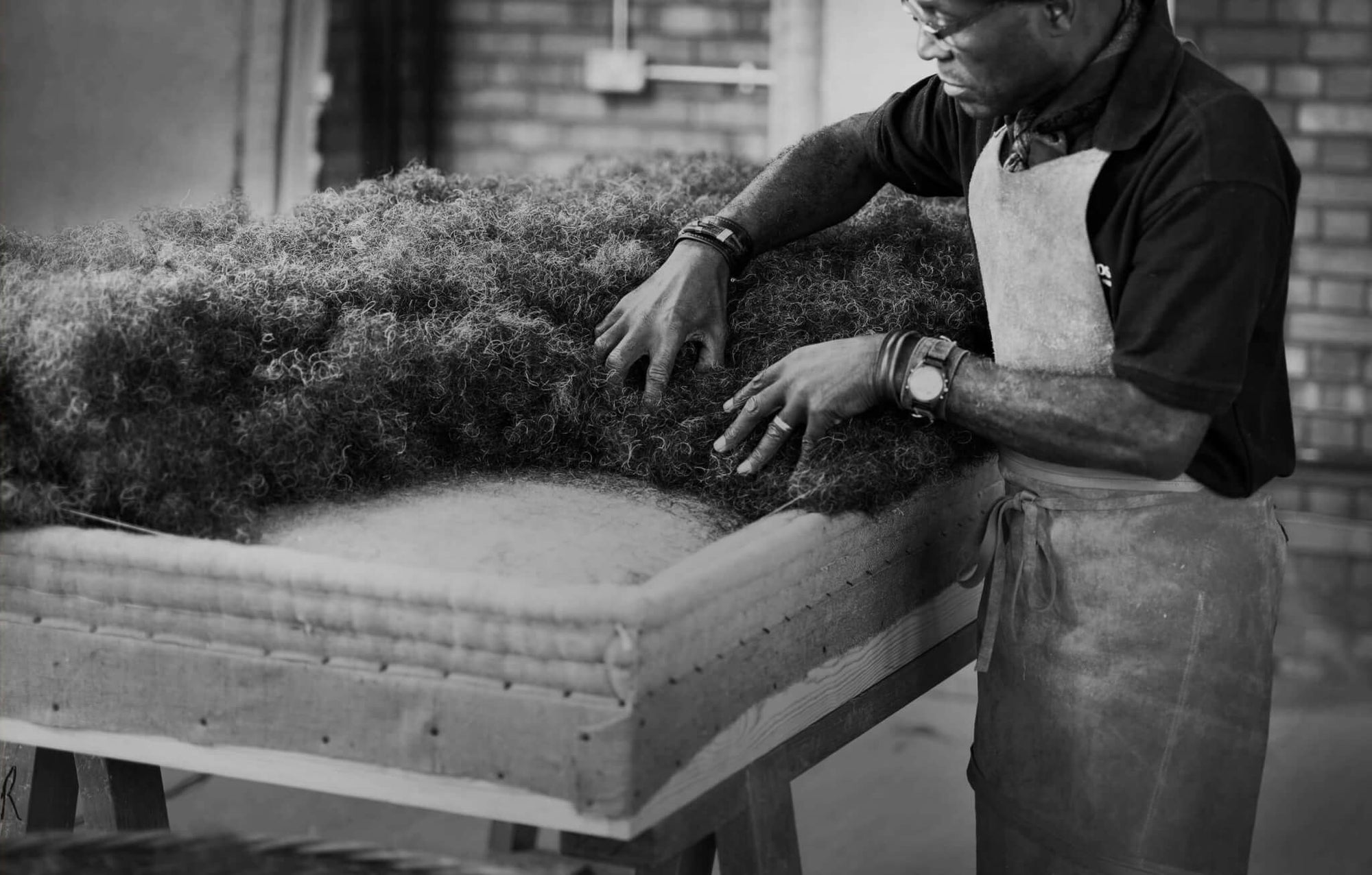 A craftsman laying horsehair on a Savoir's base